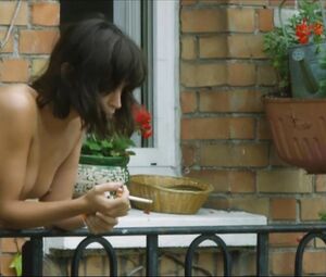 Lewd Vimala Pons is watched by man smoking on balcony in J'aurais Pu être Une Pute